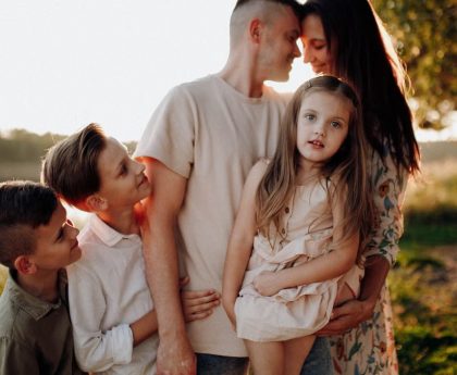 Family enjoying quality time together outdoors by the lake during sunset.