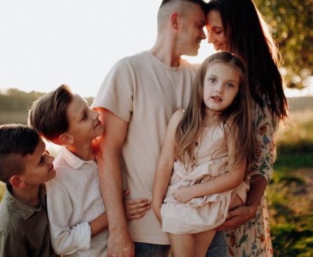 Family enjoying quality time together outdoors by the lake during sunset.